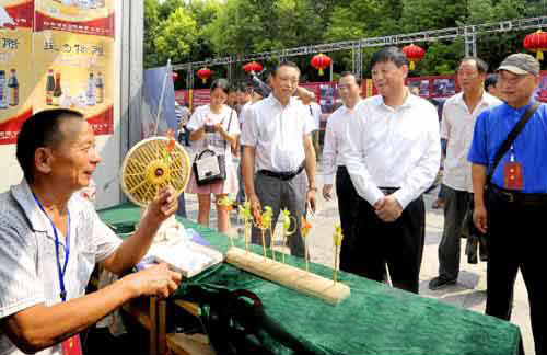余學(xué)友察看“中國農(nóng)加工洽談會”非物質(zhì)文化遺產(chǎn)展展區(qū)