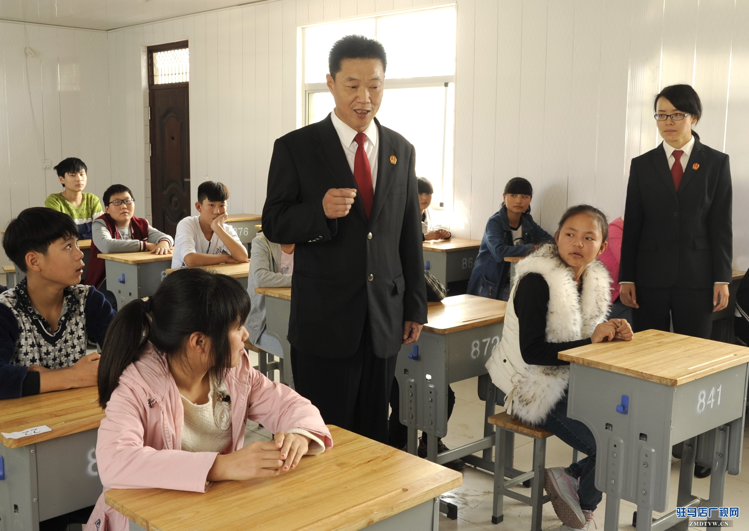 【04】泌陽(yáng)縣人民法院少年家事綜合審判庭的杜偉法官，正在向“旁聽(tīng)席”上的初中學(xué)生們講解法律知識(shí) (1).jpg