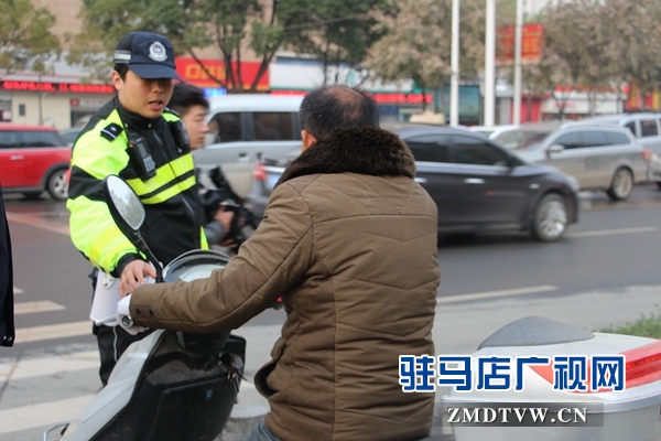 剛到路口，民警就攔住一位騎電動車闖紅燈的.JPG